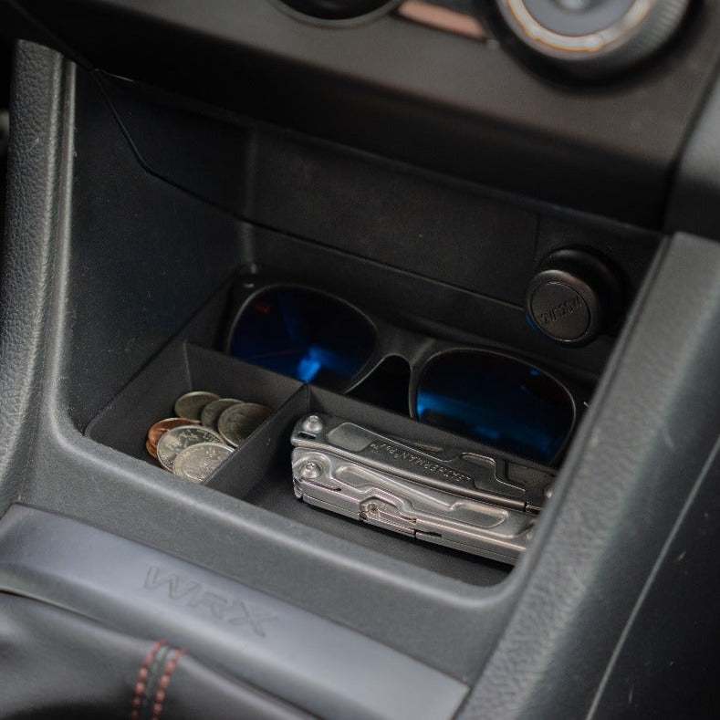 Close-up view of the VOXELWERKZ black center console tray in a Subaru WRX, showcasing divided compartments for efficient storage of accessories like sunglasses and coins.